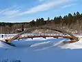 Arch bridge over the frozen Pirita in winter in Kose