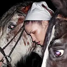 A woman pictured alongside two horses