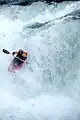 Aerial shot of a kayaker in a red kayak on rapids