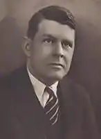 A black-and-white photographic portrait of a middle-aged Lee from the shoulders up, wearing a suit