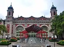 Entrance to the Main Building, seen from the south. The entrance canopy can be seen in the foreground, and the three arches of the south facade, as well as two of the ornamental towers, can be seen in the background.