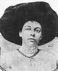 A young white woman wearing a large black hat.