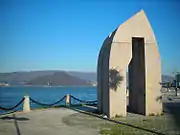 Sculpture on the harbour promenade with the island of Tambo in the background.