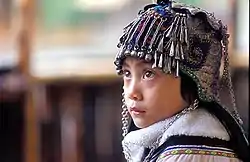 An ethnic Hani girl with a typical Hani headgear for children. Near Yuanyang, Yunnan Province, China.