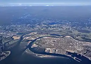 An aerial view of Everett, showing residential neighborhoods surrounded by a river delta and sprawling homes in the background.