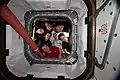 The six-member Expedition 59 crew poses for a portrait looking through the vestibule between Node 1 (Unity) and Northrop Grumman's Cygnus commercial space freighter. The closeout covers a full complement of rotated CPAs.