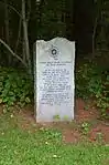 A monument at Father Rale's grave memorializing his work.