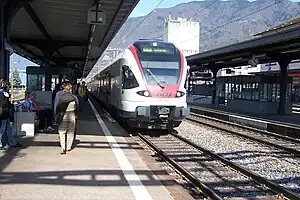 Red-and-white train on double-track at island platform