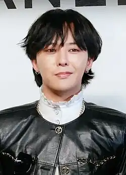 G-Dragon wearing black and white, looking towards the camera