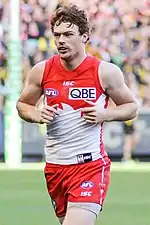 Male athlete running on playing surface of Australian rules football ground