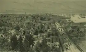 Sketch of Georgetown, Demerera, British Guiana showing  the town on the left, people and horses walking on the main waterfront street, and the harbour on the right, filled with ships