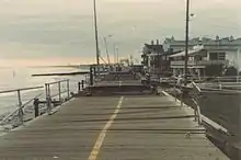 A boardwalk in Ocean City, New Jersey, is shown to have been buckled and eroded by Hurricane Gloria.