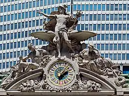 A large clock and stone sculptural group adorning the building's facade