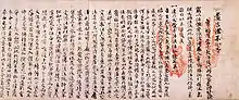 Text in Chinese script on paper with two red handprints.