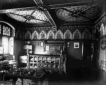 Photograph of a bed showing paintings on the headboard and the foot of the bedframe