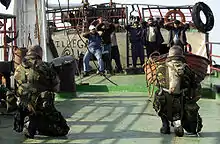 British Royal Navy sailors guard the crew of an Iraqi oil tanker in 2002