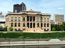 A reasonably grand three story building with French inspired architectural style constructed of salmon pink Minnesota limestone. Refer to caption.