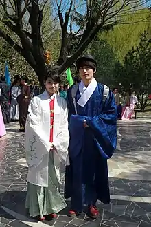 A man wearing a zhiduo and a lady wearing aoqun with beizi, 2013.