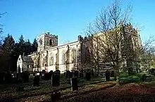 A long stone church seen from the southeast with a low tower at the far end