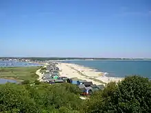 view looking down from a hill onto a sandy shoreline