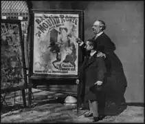 Zidler's assistant and Moulin-Rouge manager, Tremolada, pointing at Jules Chéret's 1889 poster, Bal du Moulin Rouge with Toulouse-Lautrec, Place Blanche, Paris, 1892