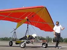 The kite hang glider is readying for being a kite in two ways; during kiting tug by the ultralight powered hang glider trike the system is a long-line kite being towed; then upon release from tug, the kite hang glider is a short-kite-lined free-flight kite with a dominant aim of gliding.