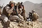 A field radio operator with 9th Communications Battalion, participating in WTI 2-13, uses a laser target designator (2013).