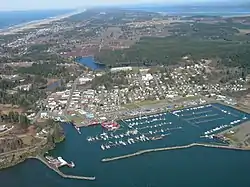 Aerial view of Ilwaco and Ilwaco Harbor. The western edge of Long Beach Peninsula is on the left, and cranberry bogs are visible immediately north of downtown Ilwaco.