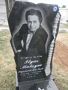 Grave of Ilyas Mallayev with an homage to his beloved instrument, the tambur, carved into the stone at Mount Carmel Cemetery in Queens, NY, USA