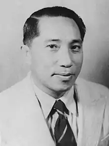 Black-and-white portrait of Herling Laoh wearing a suit-and-tie