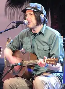 Mangum playing a guitar and singing into a microphone