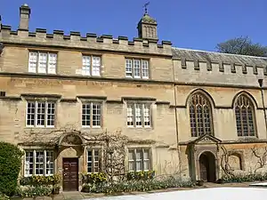 A three-storey house adjoining a chapel, both in stone and with battlements