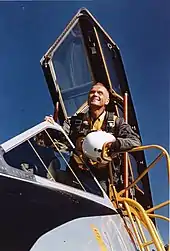 Photo of John Glenn leaning out of a cockpit looking into the distance