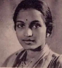 A South Asian woman with her dark hair dressed to the nape