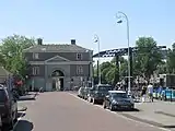 Kadijksplein square with the cast-iron bridge over Nieuwe Herengracht canal and the gate building of the Algemeen Rijksentrepot