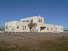 One-story building with two-story central section; rounded corners