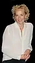 Katja Riemann in 2019 wearing a white blouse, looking to the front and smiling