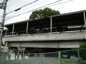 A sacred camphor tree with a shrine at the base at Kayashima Station in Japan