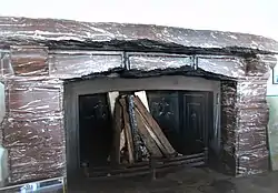 Fireplace in the Kehlsteinhaus, a present from Mussolini. Note the damage to the three central stones, which were chipped by Allied souvenir hunters.