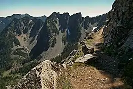 Mountainside trail with view of jagged rocky mountain with steel talus