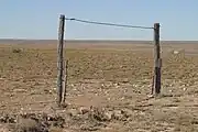 Gate leading to fenced pastureland in the wide open spaces south of Kenna, Roosevelt County, New Mexico.