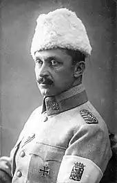 A studio-style picture of General Mannerheim, commander-in-chief of the White Army. He is looking away with his left shoulder turned towards the camera. On his left arm, a white armband shows the coat of arms of Finland.