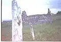 The headstone on the saint's grave and the ruins of his old church.