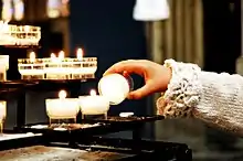 A child lighting a votive candle at the Catholic Christian Cathedral of St. Michael and St. Gudula in Brussels