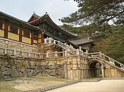 Side view of stone bridges under a wooden colorful building