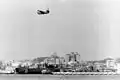 USS Duval County (LST-758) in drydock at San Diego, September 1960, with Martin P5M Marlin flying boat passing overhead