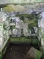 Inside the Lady's Well covering with the 'niche' at the back and the broken sandstone covering slab.