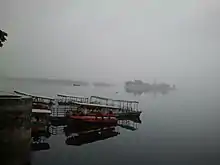 Boats floating in Lake Pichola, and Jag Mandir in background, in a typical cloudy day in rainy season.