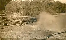 Splash of logs being dumped into a log pond.