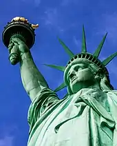 The Statue of Liberty, a large teal bronze sculpture on a stone pedestal